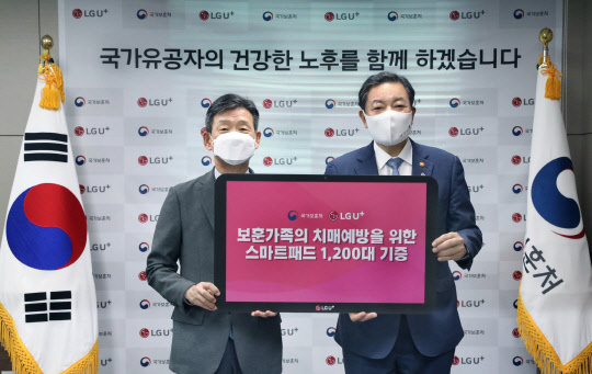 황현식(왼쪽) LG유플러스 대표와 황기철 국가보훈처장이 지난 21일 서울지방보훈청에서 진행된 '국가유공자의 노후를 위한 스마트패드 기증식'을 갖고 기념촬영 하고 있다. LG유플러스 제공